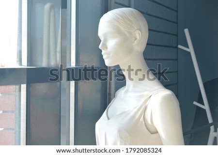 A mannequin stands in a store to try on clothes for people in the store