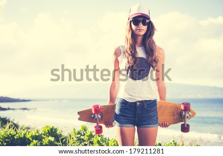 Beautiful hipster girl with skate board wearing sunglasses Royalty-Free Stock Photo #179211281