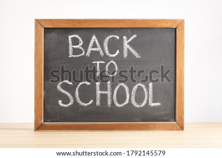 Back to school concept. Chalkboard with handwritten text on table