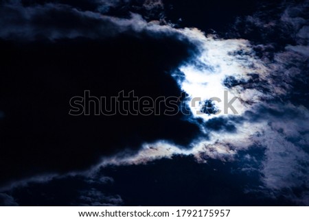 Clouds pass in front of the moon in a night sky