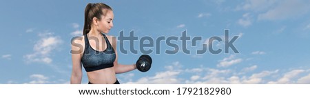 Sporty woman does the exercises with dumbbells