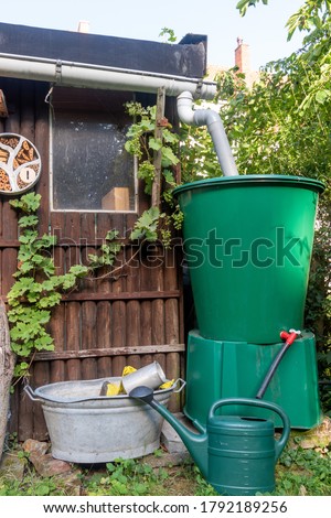 eco friendly garden with rain water collection tank  Royalty-Free Stock Photo #1792189256