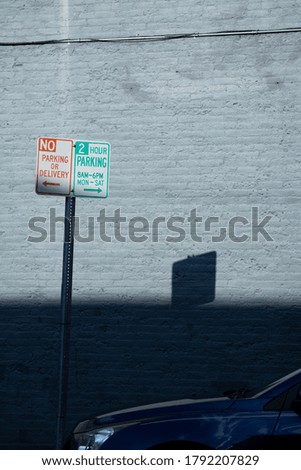No Parking Sign in Shadow with Car