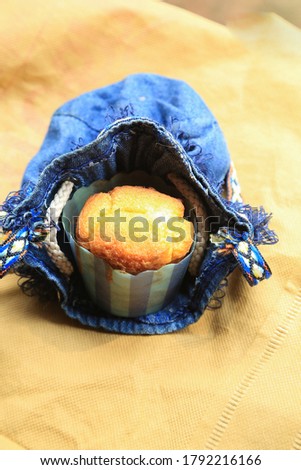 Homemade delicious muffins in a bag with creamy background