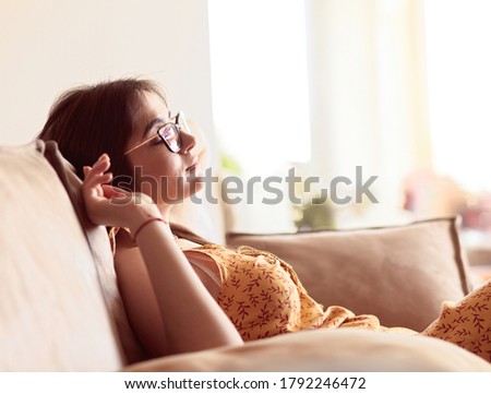 Relaxed woman sitting on a modern sofa at home