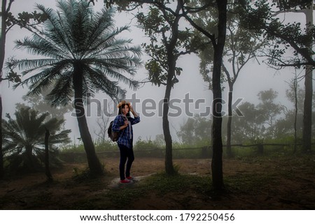 Female tourists with backpacks on misty mountains
