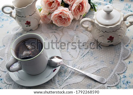 Cup of tea and the tea set some flowers,
