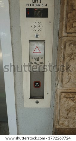 Elevator button on train station to go up to over bridge level
