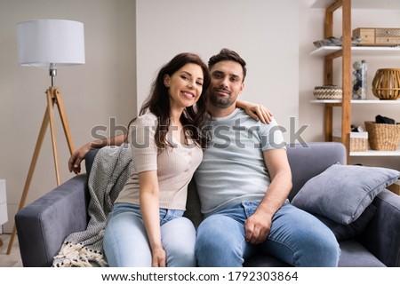 Sitted Happy Man And Woman On Sofa Or Couch At Home