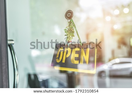 A business sign that says open in cafe or restaurant hang on door at entrance.