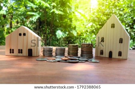The coin is stacked in four rows, graduated from the left, ascending to the right. With a wooden house model placed Money saving concept to build a house