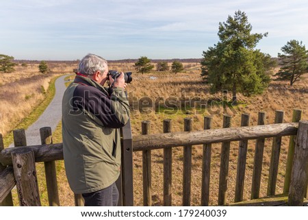 Senior man taking photos from an observation post