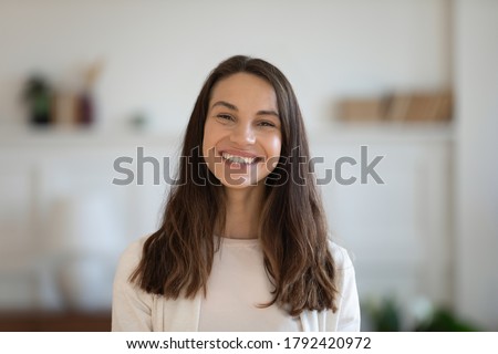 Head shot profile picture of smiling attractive mixed race woman. Happy caucasian girl looking at camera, enjoying communicating with friends via video call. Female client satisfied with service.