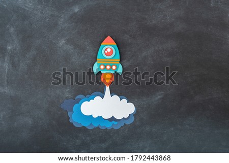 Rocket takes off paper craft. Back to school. Copy space. Black background school board. Business concept