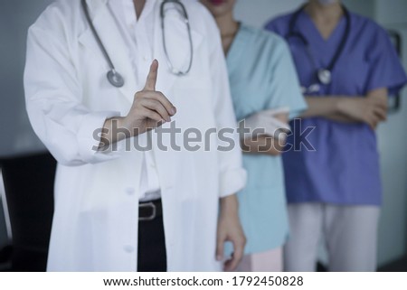 Doctor pointing up finger with medical team