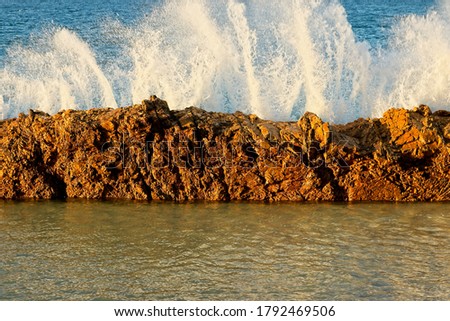 A wave crashing over a rock. A seascape background photo. 