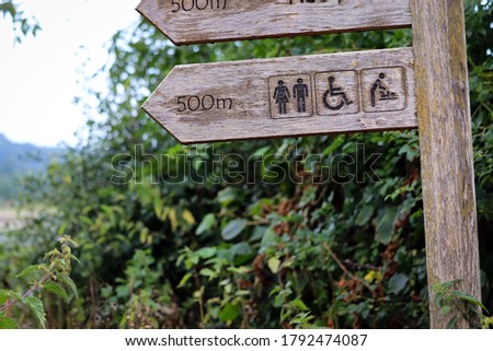Wooden sign post for the toilets