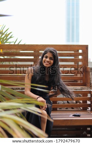 Girl with a smile sitting on a wooden bench