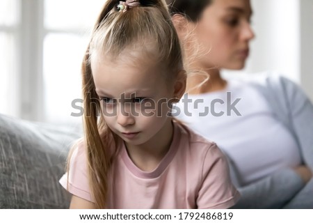Close up head shot unhappy offended little blonde child girl turning away from upset mother, feeling stressed after quarrel or misunderstanding, family conflict, different generations gap concept. Royalty-Free Stock Photo #1792486819