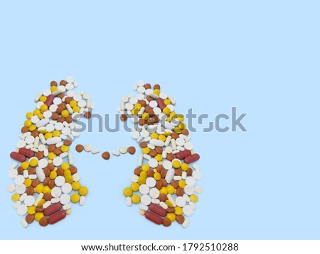 Kidney shaped medicine arranged on blue background with copy space