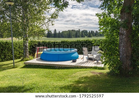 Finnish country house yard. Playground. Children's playhouse. Inflatable pool in the yard. Royalty-Free Stock Photo #1792525597