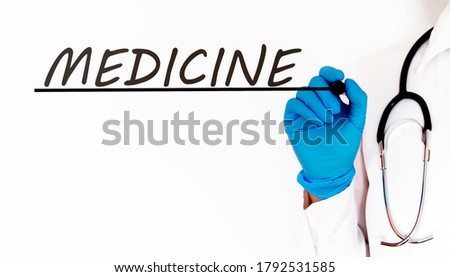 Doctor writing text MEDIcine .Medical concept on white background