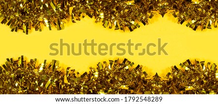 Christmas background. yellow tinsel Christmas decoration seamless isolated on yellow background. 