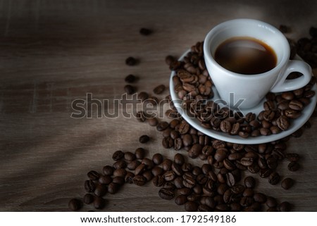 On the table is one Cup of coffee on a saucer with scattered coffee beans. High quality photo