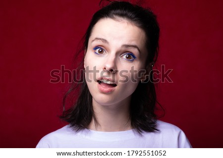 surprise woman in a light T-shirt on a red background