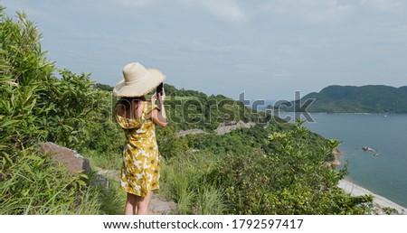 Woman use cellphone to take photo on mountain