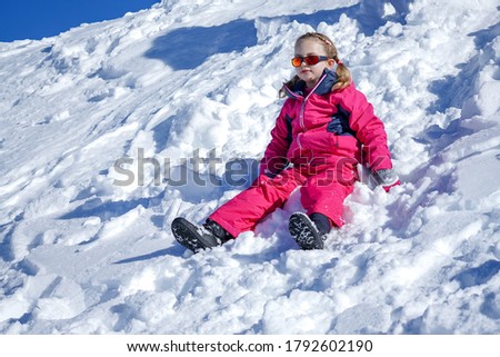 Young Girl Sitting On The Snow Mountain. Winter time
