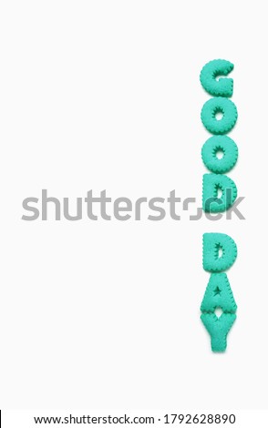 Text of GOOD DAY spelled with aqua blue alphabet shaped cookies on a white background