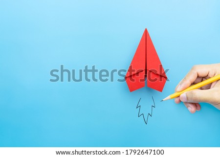 Startup concept, Red paper plane and businessman hand drawn launching plane on blue background, copy space