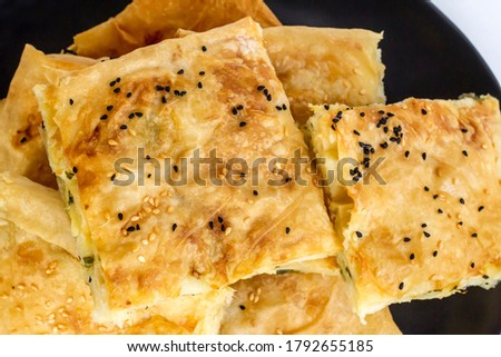 Traditional Turkish homemade tray pastry sliced in black round plate,top view