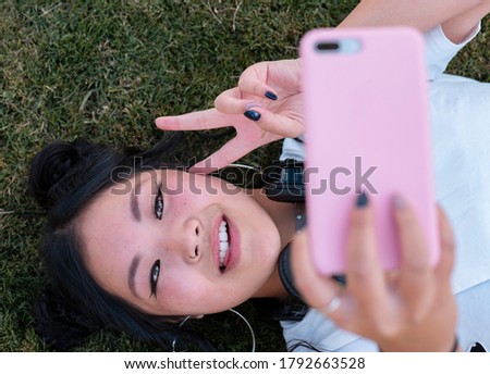 chinese woman taking photos on the grass