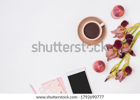 Flat lay composition with a cup of coffee and irises flowers on a white background