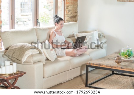 young woman using laptop computer while sitting on a couch at home. working from home