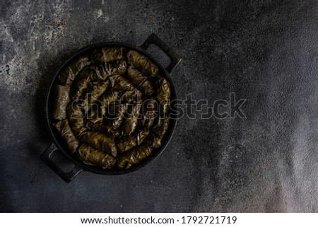 Traditional georgian tolma in vine leaves on rustic background with copyspace