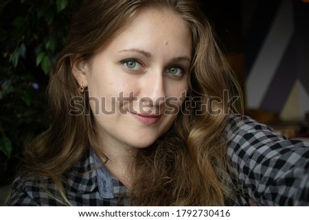 Beautiful young European woman looks at the camera. A nice woman takes a selfie. Talk face to face.