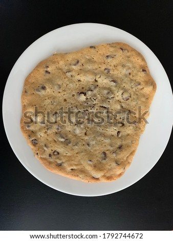 A picture of a giant chocolate chip cookie.