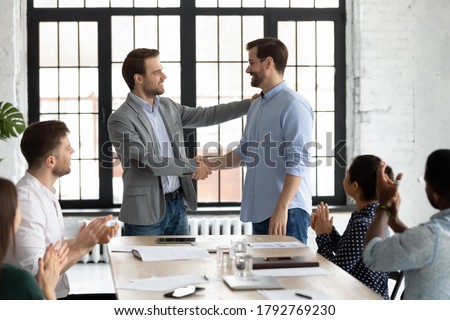 Smiling executive shaking successful employee hand, congratulating with job promotion, thanking for good work results, diverse employees applauding to colleague, appreciation and recognition Royalty-Free Stock Photo #1792769230