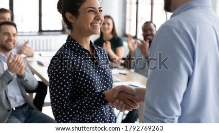 Close up executive shaking smiling Indian businesswoman hand at meeting, diverse colleagues applauding, team leader congratulating successful employee with job promotion, thanking for good work Royalty-Free Stock Photo #1792769263