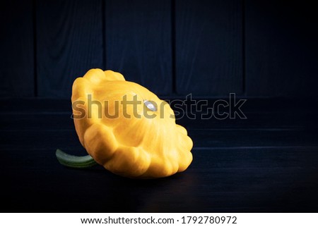 Yellow zucchini on a dark wood background. Food background with place for text