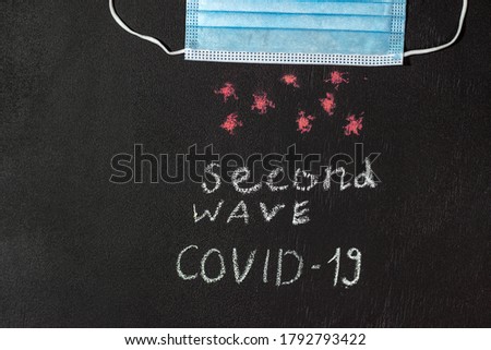 Second wave of coronavirus. Written on the board. On a black background, the second wave of COVID-19. Black textured school board