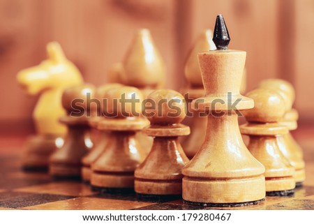 Chess leader led king his army white wooden figures. Concept game. Close up focus