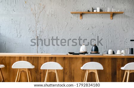 Seat and wooden counter with coffee equipment and wooden shelf on rough cement wall. design for cafe or home Royalty-Free Stock Photo #1792834180