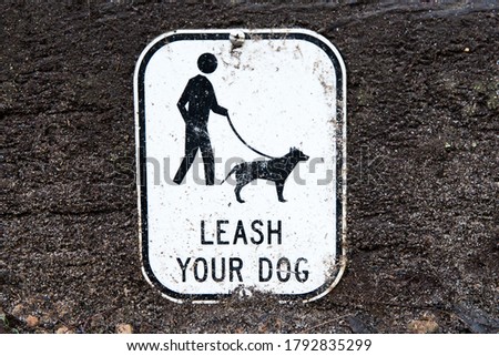 Sign in outdoor park warning people to keep their dog on a leash
