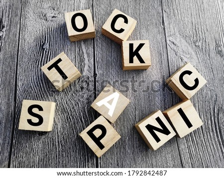 concept image a wooden block and word - STOCK PANIC with selective focus on the wooden background.

