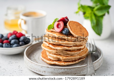 Healthy oat pancakes with berries on a craft ceramic plate. Vegan breakfast food Royalty-Free Stock Photo #1792891189