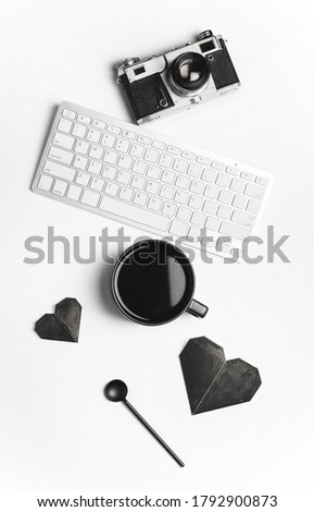 Composition with cup of coffee, PC keyboard and photo camera on white background